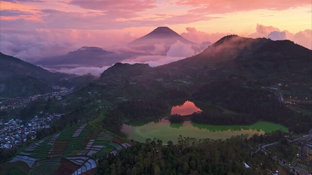 autumn mountain at sunrise and green lake with reflection and colorful dramatic sky at Indonesia