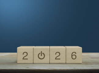 2026 start up business flat icon on wood block cubes on wooden table over light blue wall, Happy new year 2026 success concept