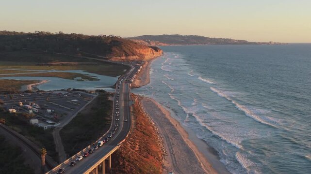 Traffic is backing up at Torrey Pines State Beach in Del Mar, California. San Diego beach at sunset, drone view.