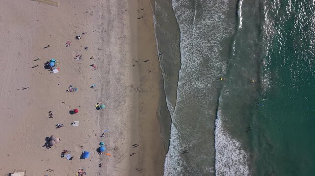 Moonlight beach in Encinitas, California. Top down drone view of people enjoying the beach.