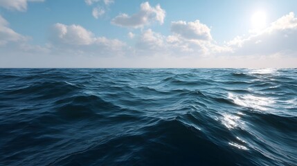 Obraz premium A vast deep blue ocean with gentle waves under a bright sunlit sky scattered with soft white clouds reflecting the sunlight