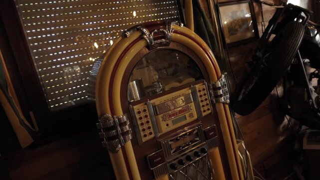 Classic jukebox standing indoors surrounded by wooden decor