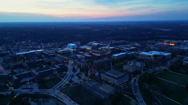 An expansive aerial view captures the Iowa State University campus in Ames, Iowa, as twilight settles.