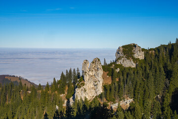 The Kampenwand, a well-known mountain peak in the Chiemgau Alps in Bavaria. Mountain landscape with coniferous forest and rock formations rising from a sea of clouds above Lake Chiemsee.
