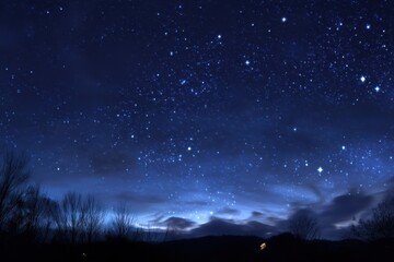 Fototapeta premium Capturing the breathtaking beauty of a midnight sky filled with stars over a serene landscape, where the dark blue hues create a tranquil atmosphere perfect for stargazing