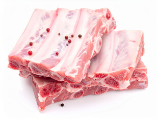 Raw pork ribs stacked with peppercorns on a white background raw meat