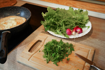 A bunch of red radishes are displayed on a green leaf. The radishes are fresh and ready to be eaten