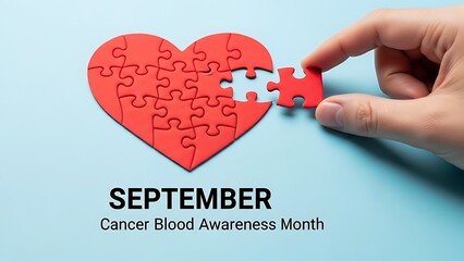 Hand completing red heart puzzle for Cancer Blood Awareness Month