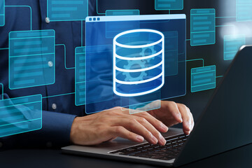 Database development and design. Data modeling and class diagrams. Programmer using laptop computer to optimize data warehouse.