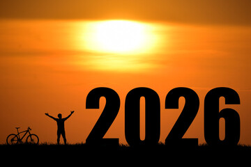 A person celebrating new year 2026 at sunset with a bicycle