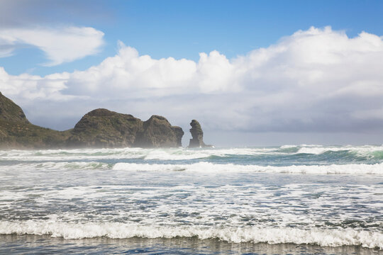 Scenic Piha Beach coastline with waves and rocks New Zealand