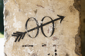 Painted toilet symbol with zeros and arrow on old wall in Austria