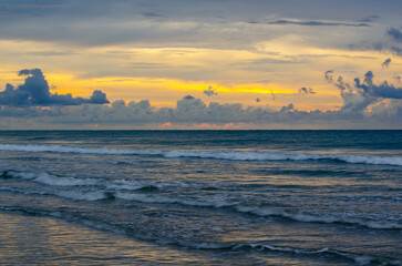 Obraz premium Golden hour ocean scene with warm sky, textured waves, and a bright band of sunlight, Kuala Penyu, Sabah, Malaysia.