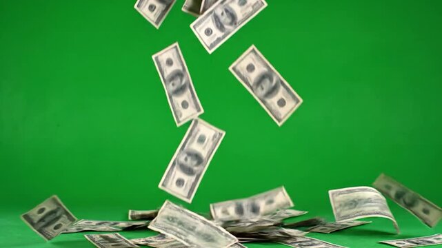 US dollar bills are falling against a vibrant green background, some on the floor