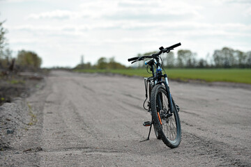 Mountain bike. stands on a field road. spring or autumn. concept of cycling, repair or breakage, sports, outdoor activities. bike on trail, front wheel in focus. healthy lifestyle © Oleksandr Filatov