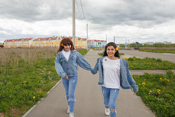 Two smiling girls on a walk. Positive emotions. Friendship