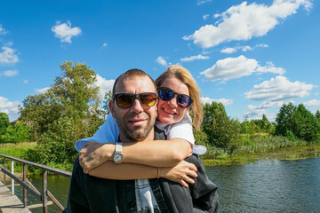 A smiling couple in love, enjoying each other's company in the great outdoors on a sunny summer day.