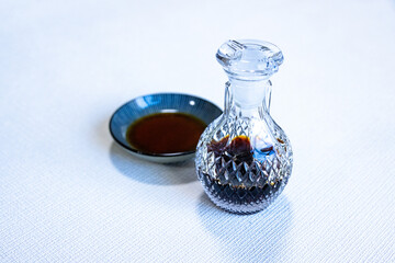 ガラス製の醤油差しと醤油が注がれた丸い小皿