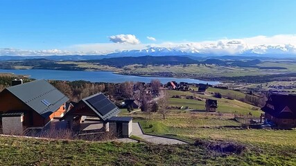 HUBA, POLAND - MARCH 28, 2024: 
A wooden houses in village located high with panoramic view over the Tatras in Podhale, Poland.