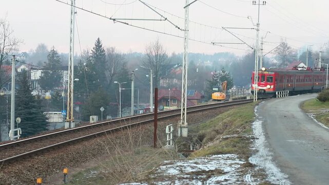 RABA WYZNA, POLAND - DECEMBER 27, 2025: The PolRegio train runs on tracks through the small town of Raba Wyzna.