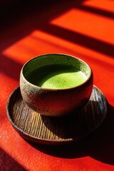 Close-up of green, frothy beverage in a ceramic bowl, sitting on wooden coaster