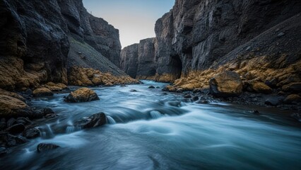 Obraz premium Deep canyon with river, dark rock walls, golden moss, long exposure, serene, dusk
