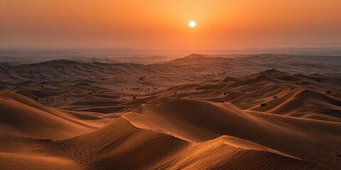 Panoramic view of desert dunes at sunset, casting warm orange glow across the landscape