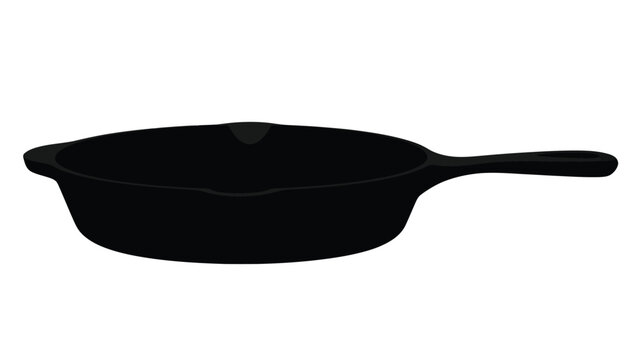 A black cast iron skillet shown in a dark striking silhouette