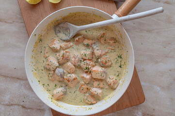 Delicious cubed salmon with  dill cream sauce in a skillet fresh and homemade cooked