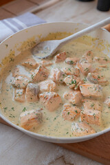 Delicious cubed salmon with  dill cream sauce in a skillet fresh and homemade cooked