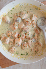 Delicious cubed salmon with  dill cream sauce in a skillet fresh and homemade cooked