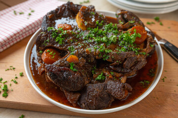Homemade fresh cooked braised beef shanks with gravy on a platter in the kitchen