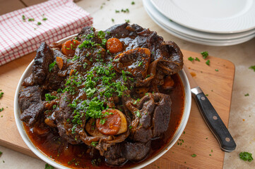 Homemade fresh cooked braised beef shanks with gravy on a platter in the kitchen