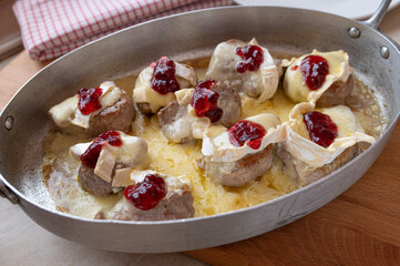 Baked pork tenderloin with camembert and cranberries in a baking dish fresh and homemade cooked