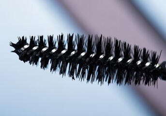 Black mascara applicator brush macro — close-up bristles and spiral wand, cosmetic product detail