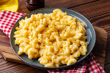 Delicious mac and cheese in a plate on wooden background