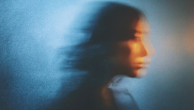 Profile of a blurred person in shades of blue and gold, suggesting movement