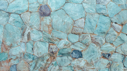 Teal and slate blue stone wall texture background with rustic irregular masonry.