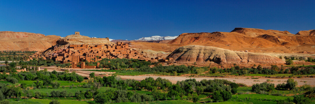 Ouarzazate, Marokko, Kashbah Ait Benhaddou  mit dem Fluss Asif Mellah und dem Hohen Atlas im Hintergrund