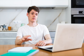 Young man chatting on the internet using laptop