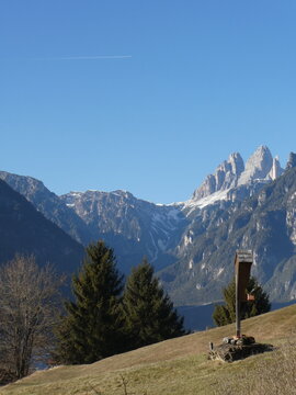 Early winter landscape with snow-covered Tre Cime di Lavaredo above green alpine meadows in Auronzo di Cadore, Dolomites, Italy