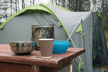 Lakeside camping scene, Camp setup by tranquil waters, Arranged campsite area near peaceful lake forest. Serene campsite prepared for outdoor meal experience. Quiet. Campground basic cooking amenities