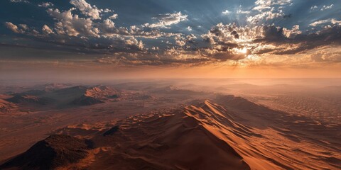 Aerial view of desert landscape at sunset, with light rays piercing through fluffy clouds