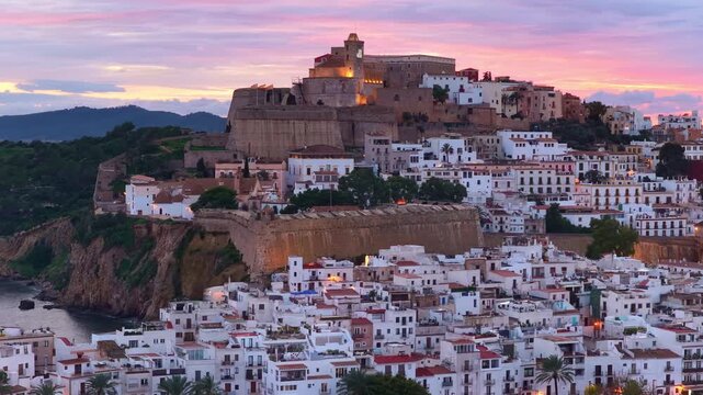 Evening in Eivissa, Ibiza, aerial view, vacation on Ibiza island, Baleares, Spain, historic Eivissa town with a fortress on Ibiza with evening lights at sunset.