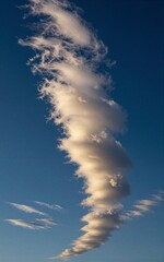 Elegant cloud swirls against deep blue sky, capturing ethereal beauty and dynamic motion.