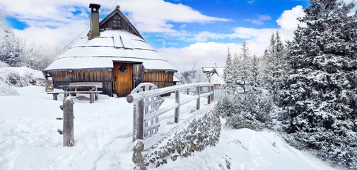 Traditional wooden cottages on a snow-covered mountain plateau, Velika Planina, Slovenia. Winter scenery 