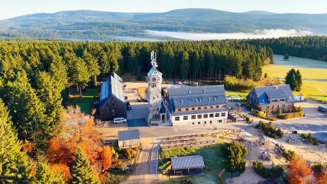 Explore the stunning Kralovka lookout tower surrounded by vibrant autumn colors in the Jizera Mountains. Enjoy breathtaking aerial views of forests and scenic landscapes.