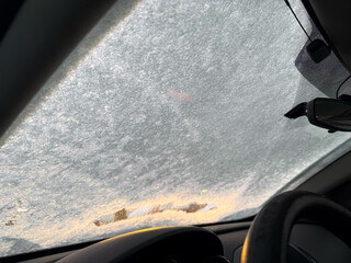 A car in the snow, snow crystals on a car in a severe frost. Winter landscape, frost. Car windows freezing during the winter season close-up. Snow Covered Car on the Street. Winter urban scene. 