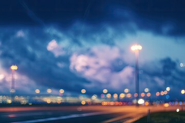 Soft focus, illuminated airport runway at dusk with moody clouds overhead