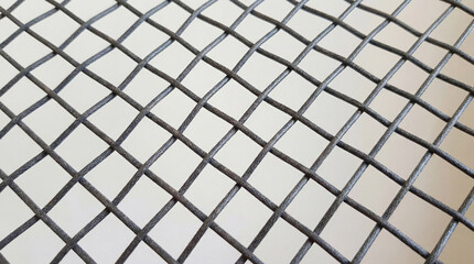 A meticulously crafted dark gray net with a diamond-shaped pattern is displayed against a luminous white backdrop, creating a sense of texture and structured order.